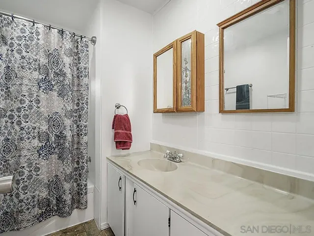 a bathroom with a sink vanity and a mirror
