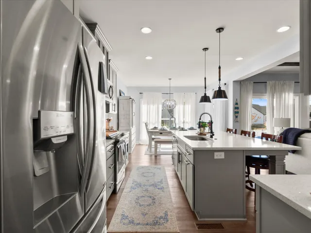 a kitchen with kitchen island a counter top space a sink stainless steel appliances and cabinets