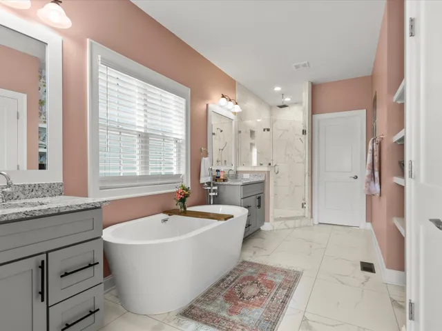 a spacious bathroom with sinks mirror and a bathtub