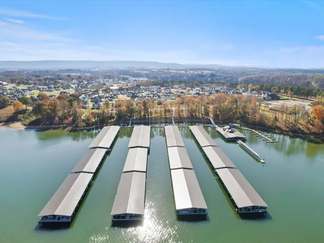 an aerial view of residential houses with outdoor space and lake view