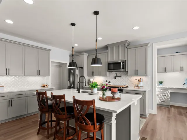 a kitchen with kitchen island granite countertop a sink a center island and appliances