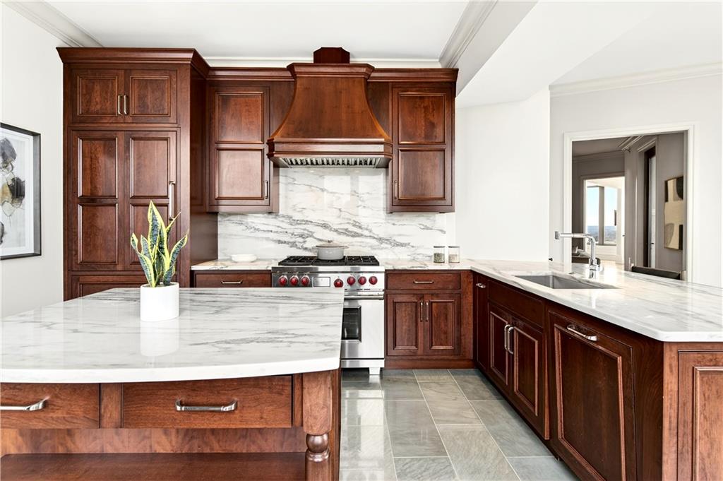 3376 Peachtree Road Northeast, Unit 41A Atlanta, GA 30326 - Photo 6 of 76 a kitchen with kitchen island granite countertop a sink stove and cabinets