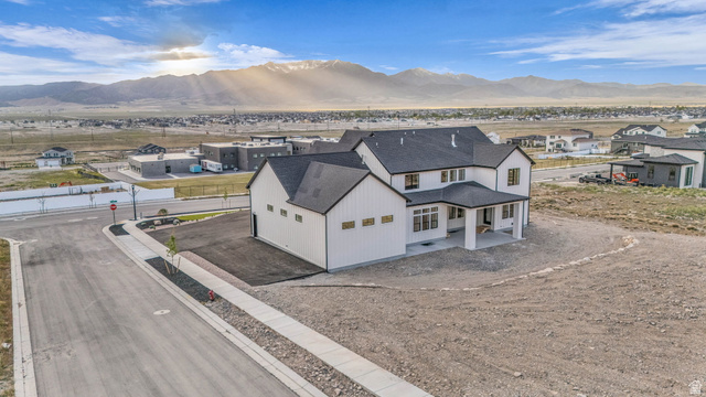 2828 Jojo Road Eagle Mountain, UT 84005 - Photo 60 of 63 Modern farmhouse architectural style featuring white board and batten siding, dark shingle roofing, and a covered porch entry