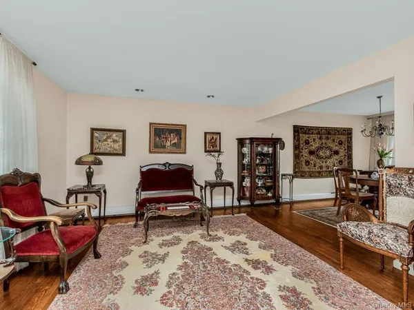 a living room with furniture a wooden floor and next to a window
