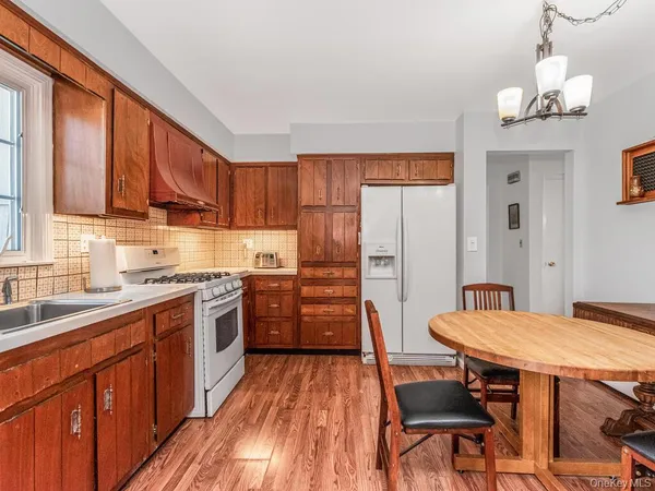 a kitchen with stainless steel appliances granite countertop a kitchen island hardwood floor sink stove dining table and chairs