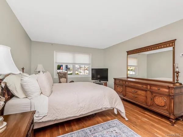a bedroom with a bed and a dresser with mirror