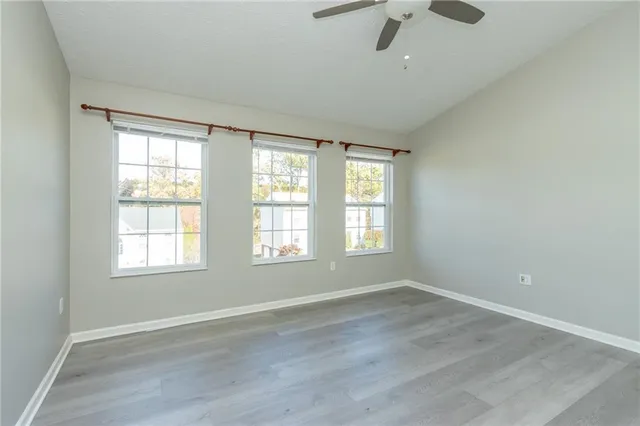 an empty room with wooden floor and windows