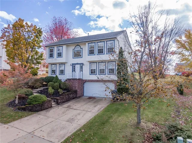 a front view of a house with a yard and trees