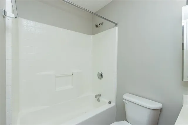 a white toilet sitting next to a bath tub
