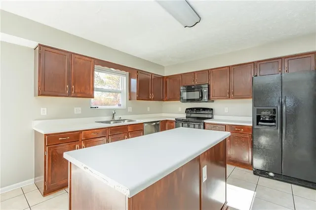a kitchen with stainless steel appliances granite countertop a sink stove microwave and refrigerator