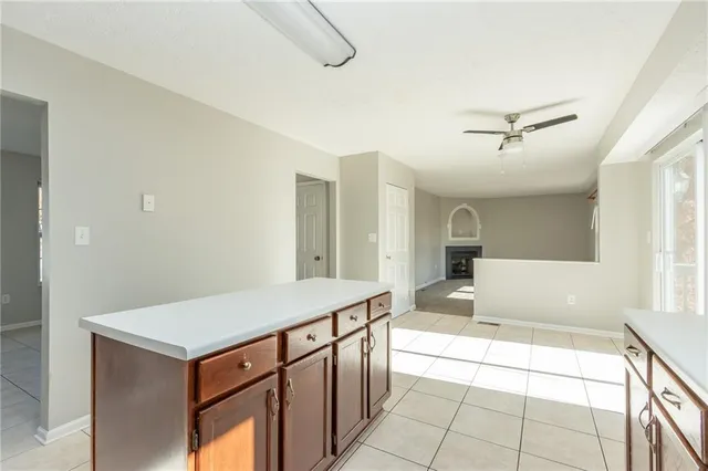 a living room with stainless steel appliances kitchen island granite countertop a sink and white cabinets