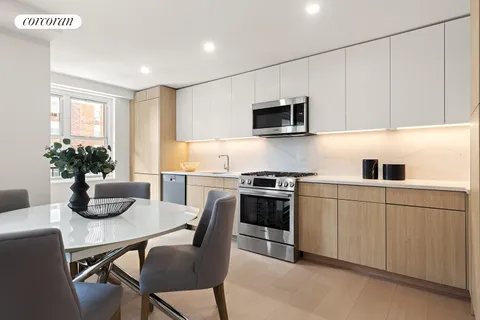 a kitchen with white cabinets and chairs