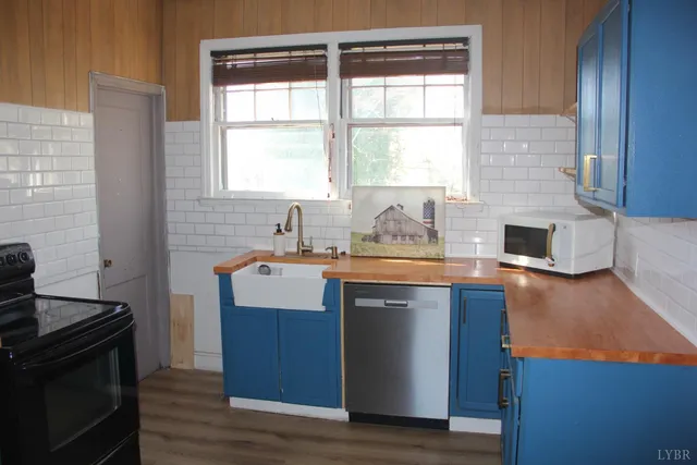a kitchen with granite countertop a stove a sink and a microwave