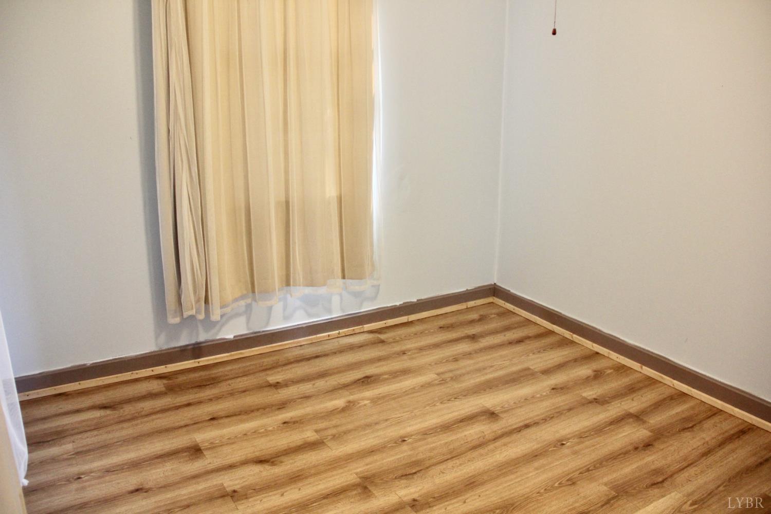 1140 Sunset Hill Road Big Island, VA 24526 - Photo 22 of 36 a view of empty room with wooden floor and fan