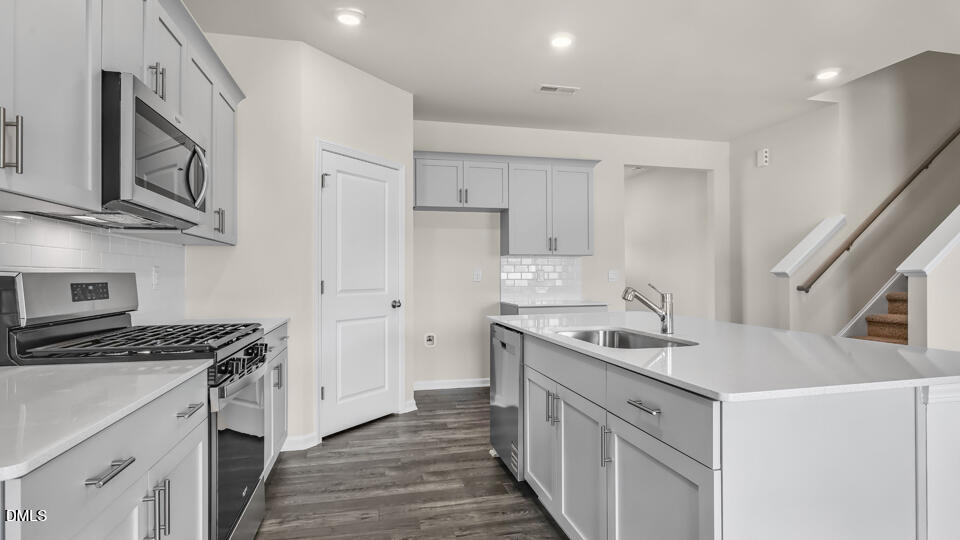 1277 Pavo Path Wendell, NC 27591 - Photo 12 of 53 a kitchen that has a lot of cabinets in it and wooden floors