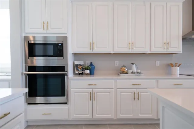a kitchen with white cabinets and stainless steel appliances