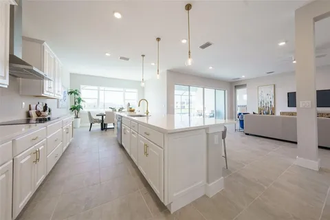 a large white kitchen with lots of counter space wooden floor and stainless steel appliances