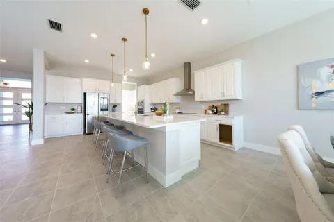 a kitchen with stainless steel appliances kitchen island granite countertop a sink and a refrigerator