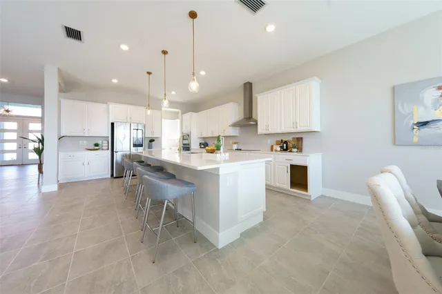 a kitchen with stainless steel appliances kitchen island granite countertop a sink and a refrigerator