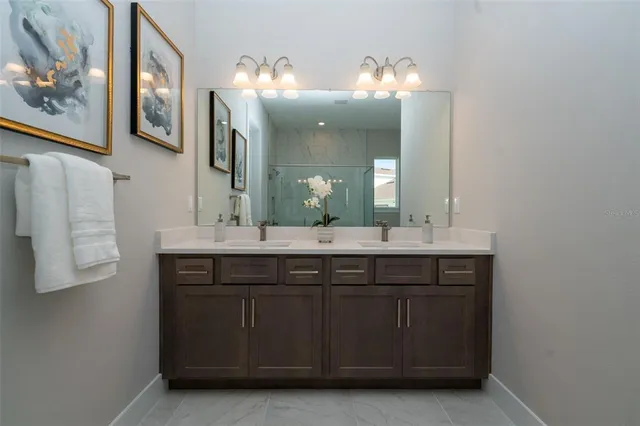 a bathroom with a granite countertop double vanity sink and a mirror
