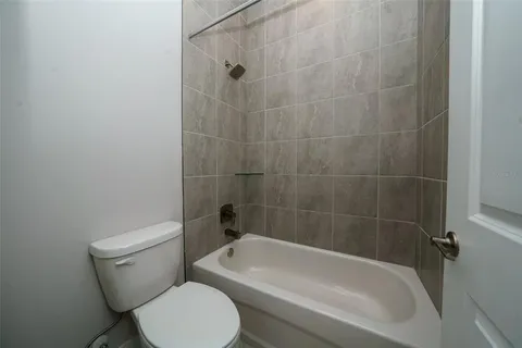 a white toilet and tub sitting next to a bathroom sink