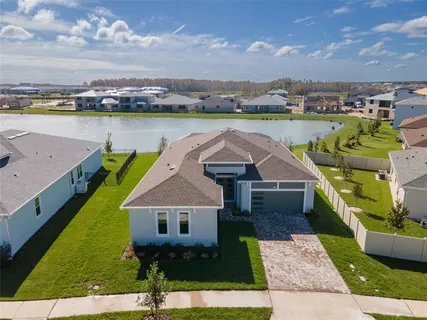 an aerial view of a house with a garden and lake view