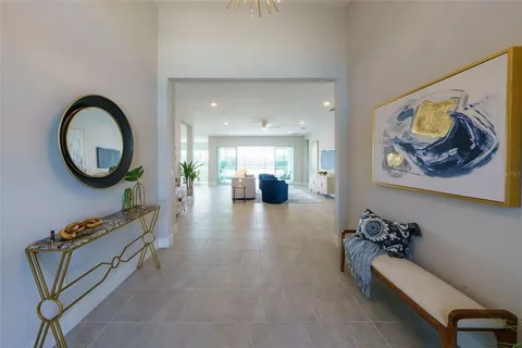 a hallway with a view of living room with furniture and a mirror