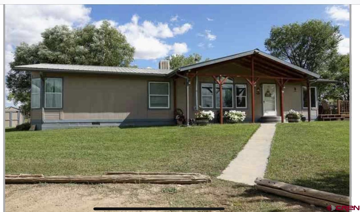 24085 Rd North Cortez, CO 81321 - Photo 1 of 34 a front view of a house with a yard