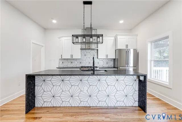 a kitchen with stainless steel appliances a refrigerator and wooden floor