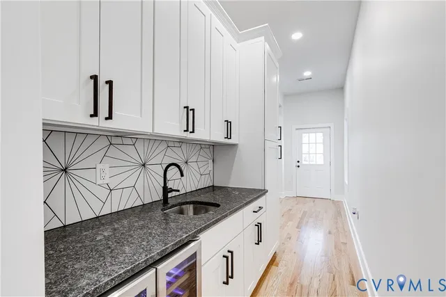 a kitchen with granite countertop white cabinets and sink