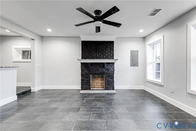 a view of an empty room with a fireplace and a window