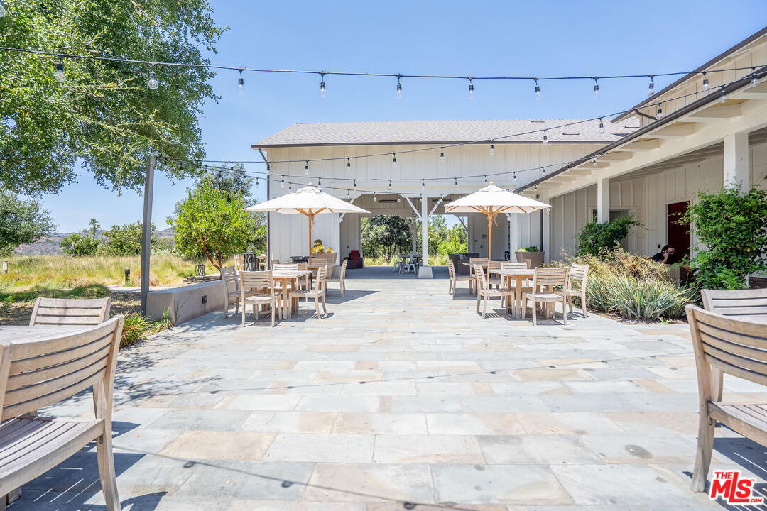17 Lustre Street Rancho Mission Viejo, CA 92694 - Photo 58 of 63 a view of a patio with dining table and chairs with plants and palm trees