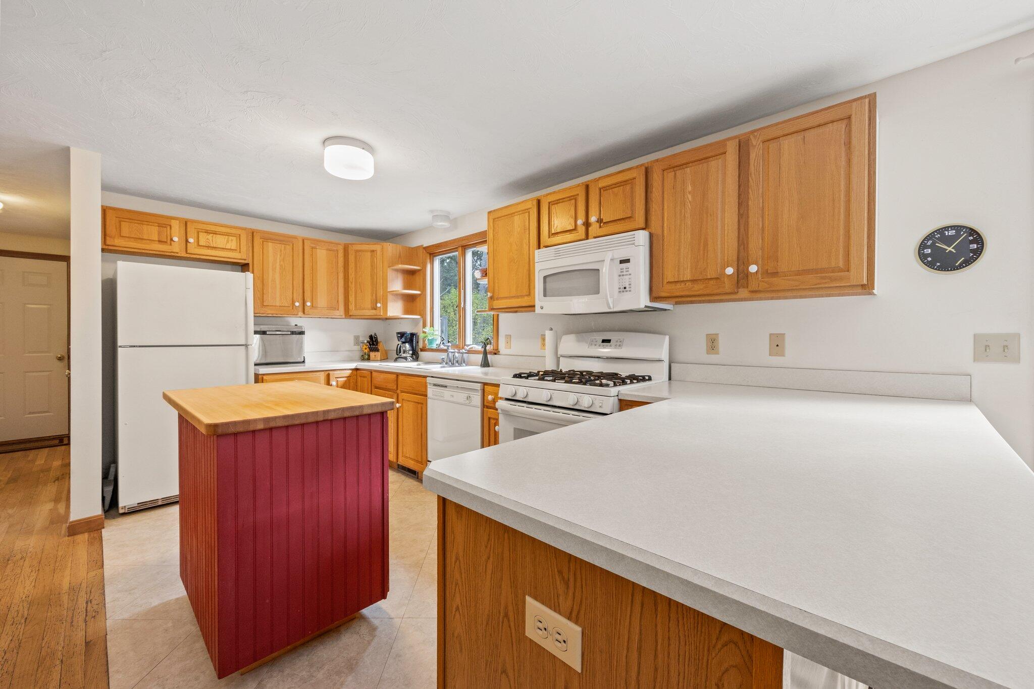 31 Hillside Road Harwich, MA 02645 - Photo 6 of 35 a kitchen with a refrigerator a stove top oven a sink and dishwasher with wooden floor