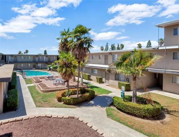 a front view of a house with a garden and tree