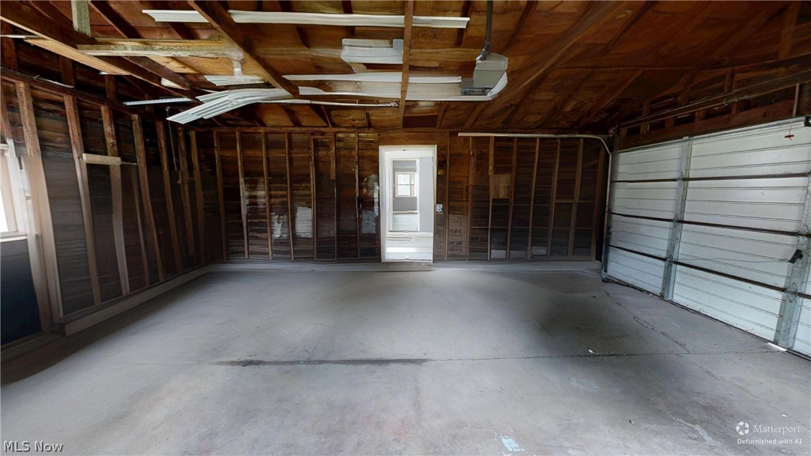 4174 Burkey Road Austintown, OH 44515 - Photo 19 of 33 Spacious two-car garage with exposed wood beam ceiling, concrete flooring, and an overhead garage door opener. Defurnished using Ai.