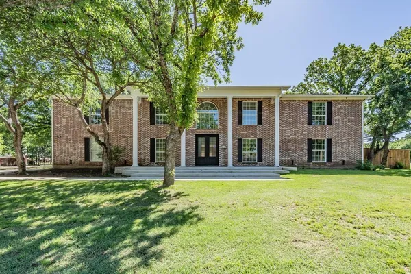 front view of a brick house with a yard