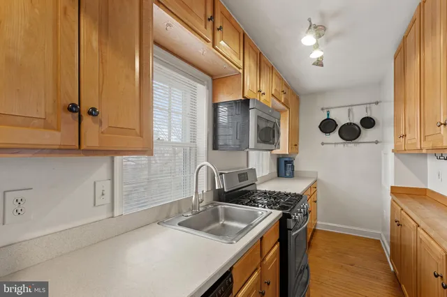 a kitchen with stainless steel appliances granite countertop a sink a stove and a refrigerator