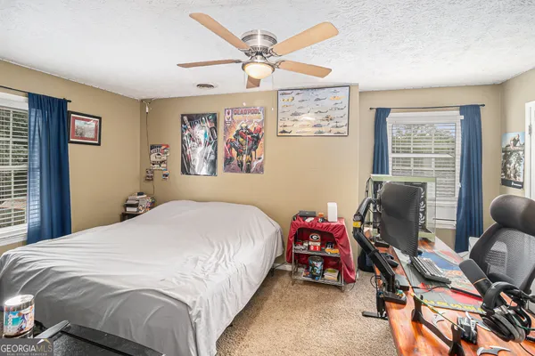 a bathroom with a granite countertop toilet a sink and a mirror