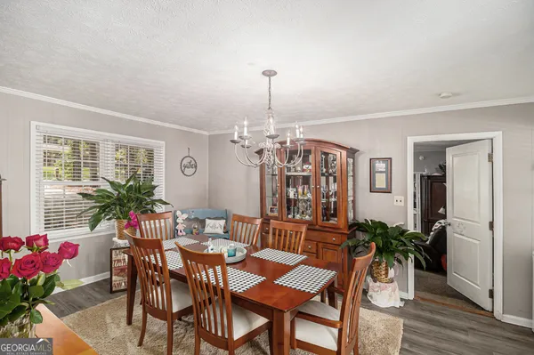 a view of a dining room with furniture and chandelier