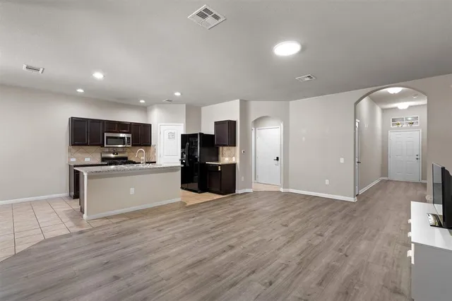 a view of kitchen with refrigerator stove microwave and cabinets