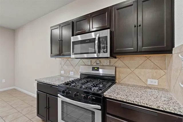 a kitchen with granite countertop stainless steel appliances and cabinets
