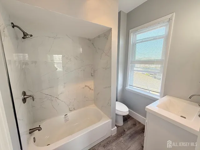 a bath room with a toilet sink and a bath tub