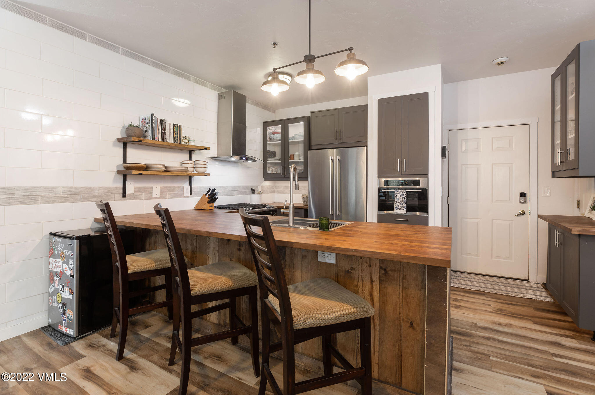 175 Hurd Lane, Unit 3101 Avon, CO 81620 - Photo 2 of 7 a kitchen with stainless steel appliances a dining table chairs and refrigerator