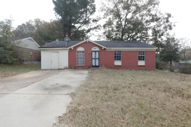 a view of a house with a yard and large tree