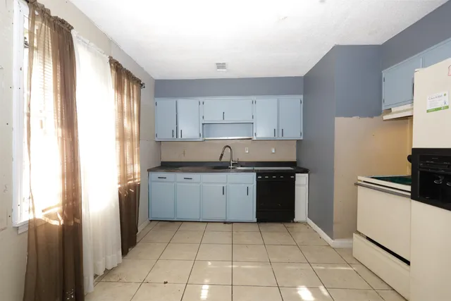a kitchen with a refrigerator stove top oven and sink