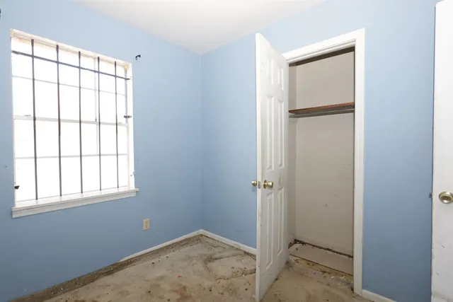 an empty room with windows and closet
