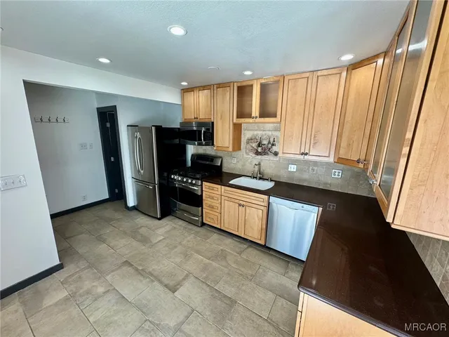a kitchen with stainless steel appliances a refrigerator and a stove top oven