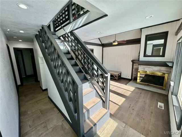 a view of staircase with lots of frames on wall and a fireplace
