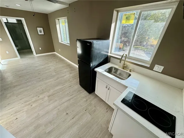 a kitchen with a sink wooden floor and a window