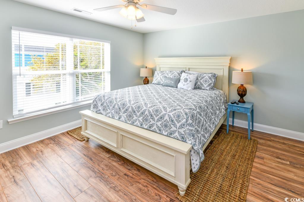 1614 North Ocean Boulevard Surfside Beach, SC 29575 - Photo 16 of 38 Bedroom with visible vents, a ceiling fan, baseboards, and wood finished floors